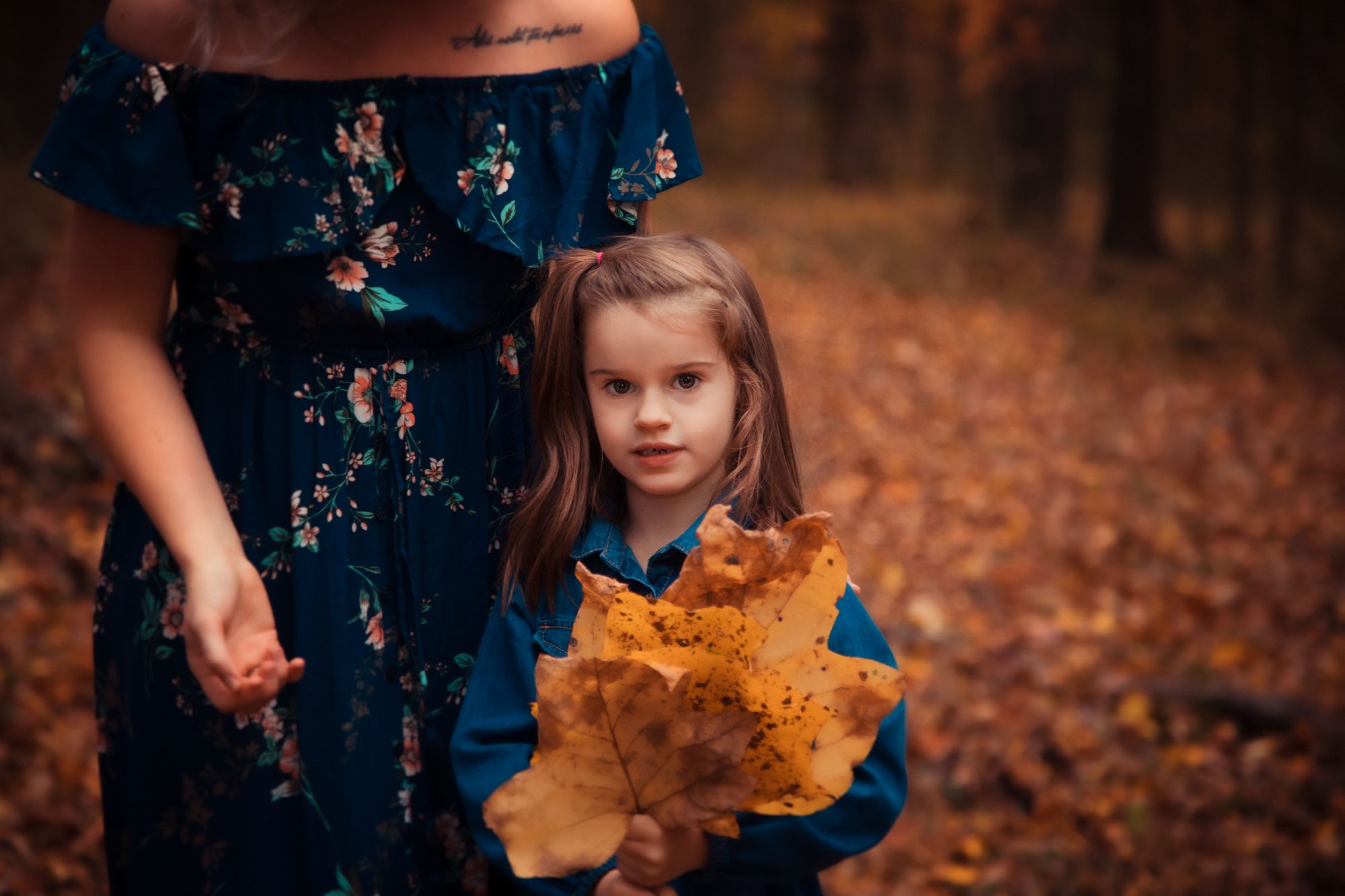 Mother and daughter in fall leaves